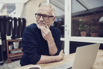 Ældre mand med kaffe og computer